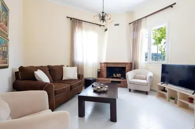 a living room with a couch and a tv at Casa Alta 2-bedroom House in Manoliópoulon