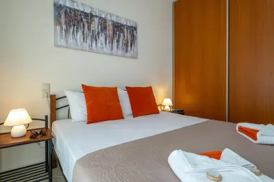 a bedroom with a large white bed with orange pillows at Villa Artemis A&B in Chania Town