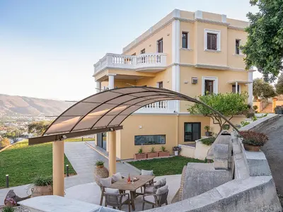 a building with a table and chairs in front of it at Mondethea vantage point home in Chania Town