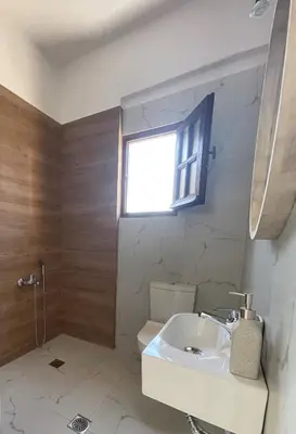 a bathroom with a white sink and a window at Nostalgia Villas in Tersanas