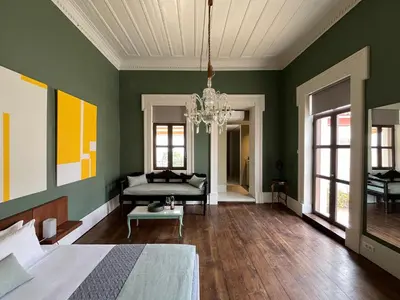 a green room with a bed and a chandelier at Thirty8 Heritage House in Chania Town