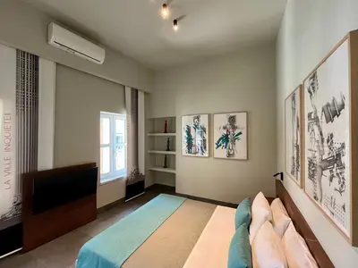 a bedroom with a bed and a flat screen tv at Thirty8 Heritage House in Chania Town