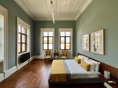 a bedroom with a bed with green walls and windows at Thirty8 Heritage House in Chania Town