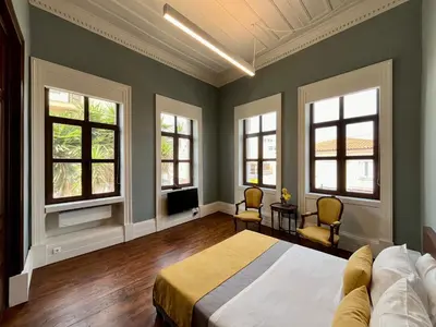 a bedroom with green walls and windows and a bed at Thirty8 Heritage House in Chania Town