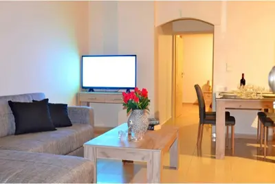 a living room with a couch and a table with a tv at LEMON TREE in Galatás