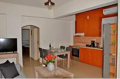 a kitchen and living room with a couch and a table at LEMON TREE in Galatás
