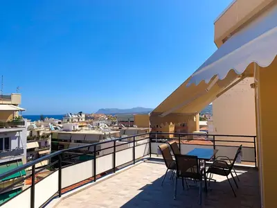 a balcony with chairs and a table on a balcony at CENTRAL HUGE LUXURY APARTMENT and FREE PARKING in Chania Town