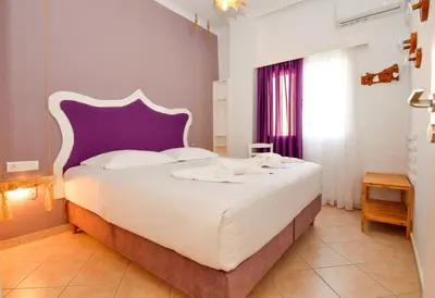 a bedroom with a large bed with a purple headboard at Rubini City Apartment in Chania Town