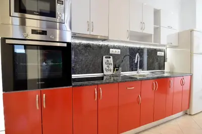 a kitchen with red cabinets and a microwave at Rubini City Apartment in Chania Town