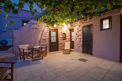 a patio with a table and chairs next to a building at Marthas DeLight Rooms in Chania Town