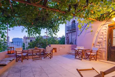 a patio with tables and chairs and a fireplace at Marthas DeLight Rooms in Chania Town