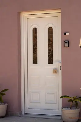 a white door with two windows on a pink wall at Tabak home Sea side apartment in Chania Town