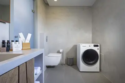 a bathroom with a washing machine and a toilet at Elixsea Villa - Unlimited view of the Blue sea in Kounoupidhianá