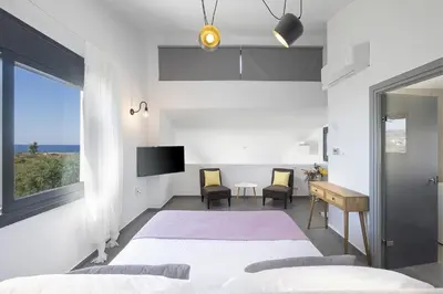 a bedroom with two beds and a window at Elixsea Villa - Unlimited view of the Blue sea in Kounoupidhianá