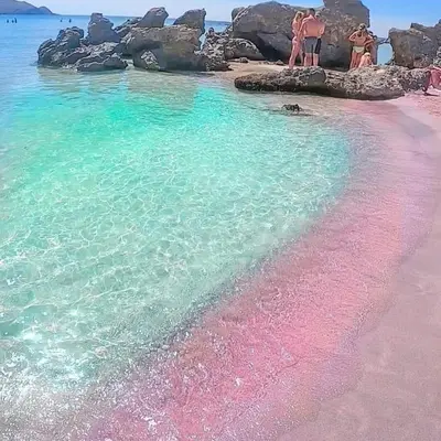 a group of people standing on a pink and green beach at Pink Sand-Studio in Agios Padeleimon
