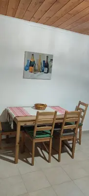 a wooden table and chairs with a picture on the wall at Ioannis Home at Skonizo in Chania Town