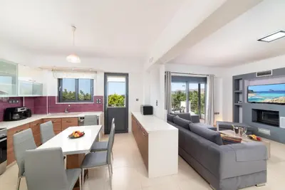 a kitchen and living room with a couch and a table at Villa Gianta in Kissamos