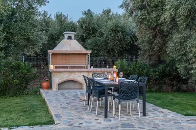 a table and chairs with a fireplace in a yard at Villa Gianta in Kissamos