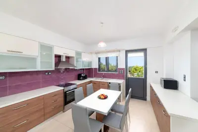 a kitchen with white counters and purple tiles at Villa Gianta in Kissamos