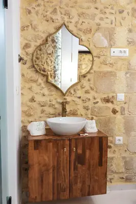 a bathroom with a sink and a mirror on a wall at La 'belle Luxury House Chania in Chania Town