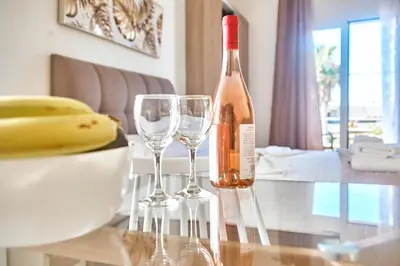 a bottle of wine sitting on a table with two wine glasses at Adele Apartment in Kissamos