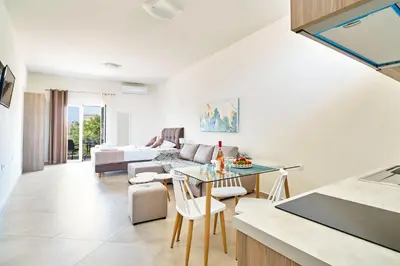 a kitchen and living room with a table and chairs at Bella Apartment in Kissamos