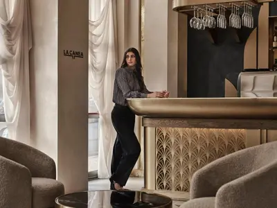 a woman standing behind a counter in a room at The Chania Hotel Crete, Vignette Collection in Chania Town