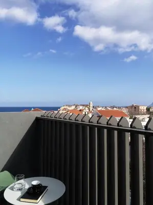 a balcony with a table and a view of the ocean at The Chania Hotel Crete, Vignette Collection in Chania Town