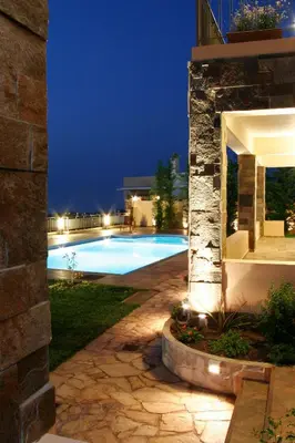 a swimming pool in a backyard at night at Caneva Luxury Villa in Tavronitis
