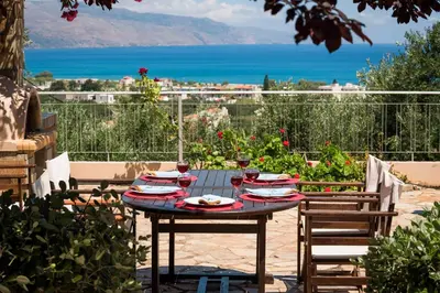 a table with plates of food on top of a patio at Caneva Luxury Villa in Tavronitis