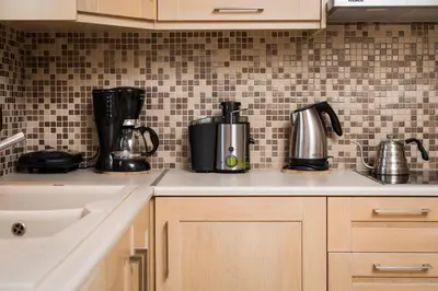 a kitchen counter with appliances on a tiled wall at Caneva Luxury Villa in Tavronitis