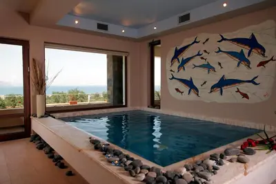 a swimming pool in a house with a painting of fish at Caneva Luxury Villa in Tavronitis