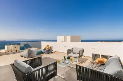 a living room with furniture and a view of the ocean at Tholaria Villa in Chania Town