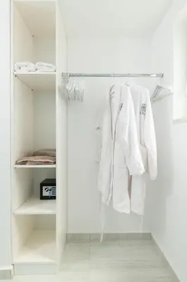 a white closet with white clothes hanging in it at Tholaria Villa in Chania Town
