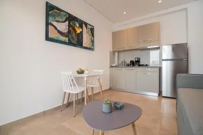 a kitchen and living room with a table and chairs at Evriali Comfort Living in Palaiochóra