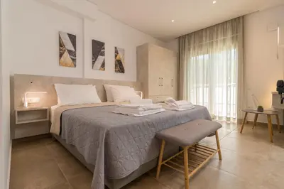 a bedroom with a large bed and a chair in it at Evriali Comfort Living in Palaiochóra