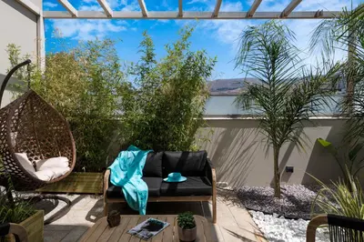 a patio with a hammock and a chair at Delight Luxury Residences - Souda in Souda
