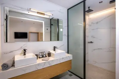 a bathroom with two sinks and a mirror at Xenias Luxury Villas Kalathas in Kalathas