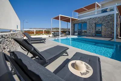 a villa with a swimming pool and a hat at Xenias Luxury Villas Kalathas in Kalathas