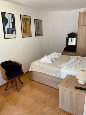 a bedroom with a bed and a chair and a table at RITSA ART RESIDENCE in Chania Town