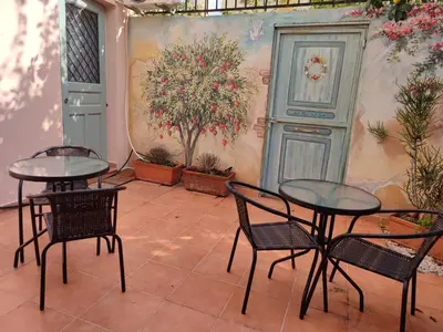 two tables and chairs in a patio with plants at RITSA ART RESIDENCE in Chania Town