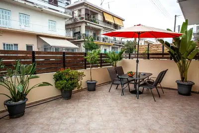 a patio with a table and chairs and an umbrella at Unique Apartment in Chania Town