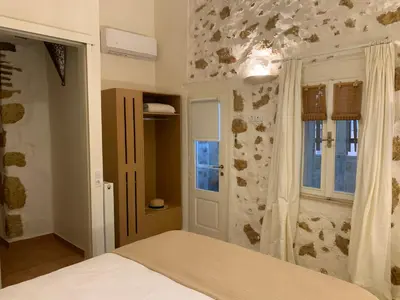 a bedroom with a bed and a stone wall at casa di nonna in Chania Town