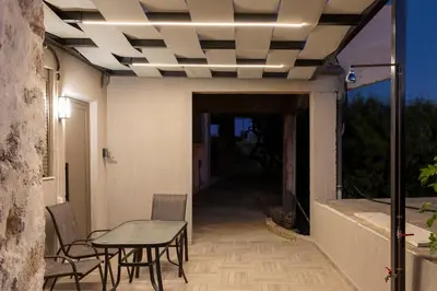 a patio with a table and chairs and a ceiling at Thea Studio in Agios Padeleimon