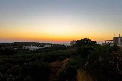 a sunset over a city with trees and buildings at Thea Studio in Agios Padeleimon
