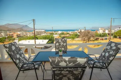a table and chairs on a balcony with a view at Strevagio family house in Kissamos