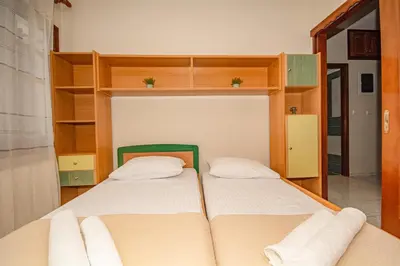 two beds in a room with wooden shelves at Strevagio family house in Kissamos