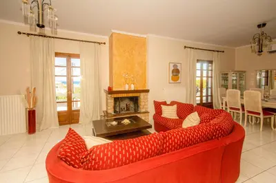 a living room with a red couch and a fireplace at Strevagio family house in Kissamos