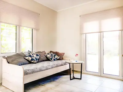 a living room with a couch and a window at Yucca Studio, beautiful apartment with garden in Ropanianá