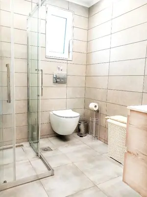 a bathroom with a toilet and a glass shower at Yucca Studio, beautiful apartment with garden in Ropanianá